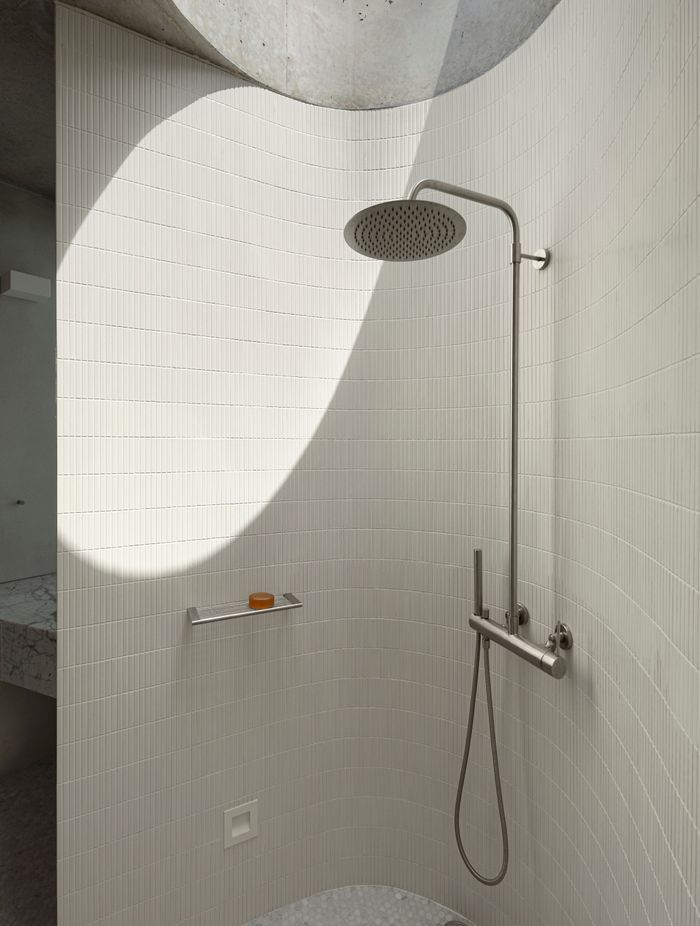 The curves of the shower room are echoed in the circular skylight.