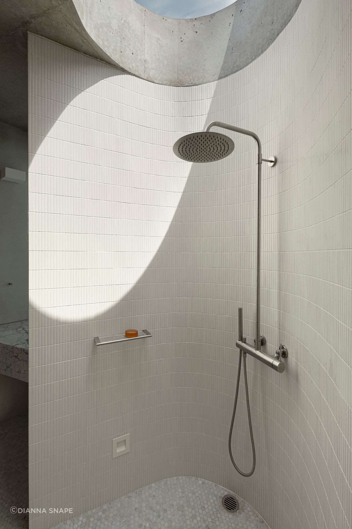The curves of the shower room are echoed in the circular skylight.