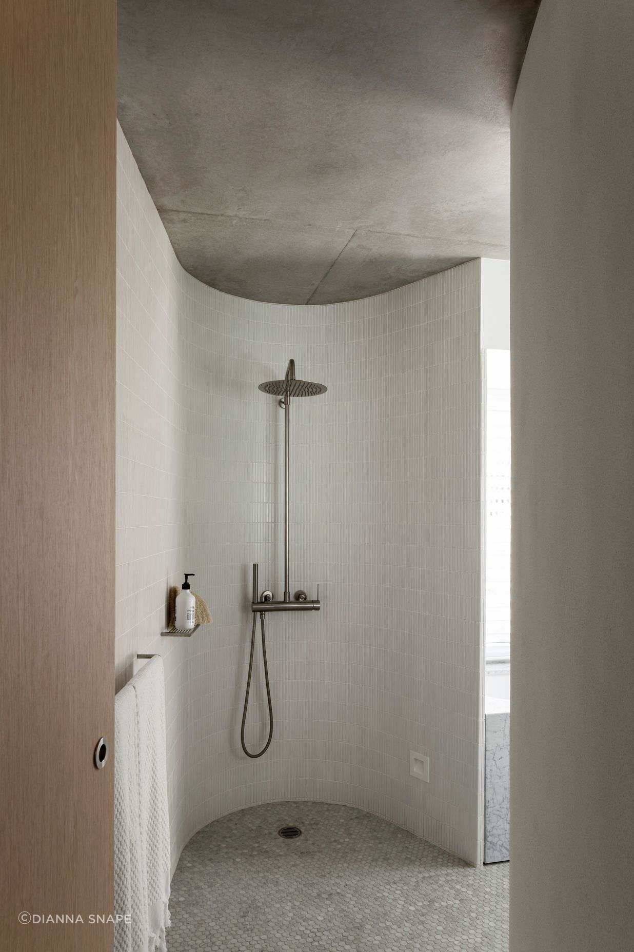 A curved shower room looks as if hewn out of stone.
