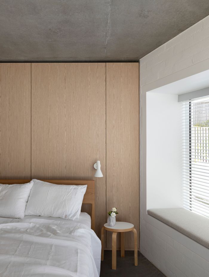 Simplicity of materiality creates a restful bedroom space with timber, concrete and white bagged brick.