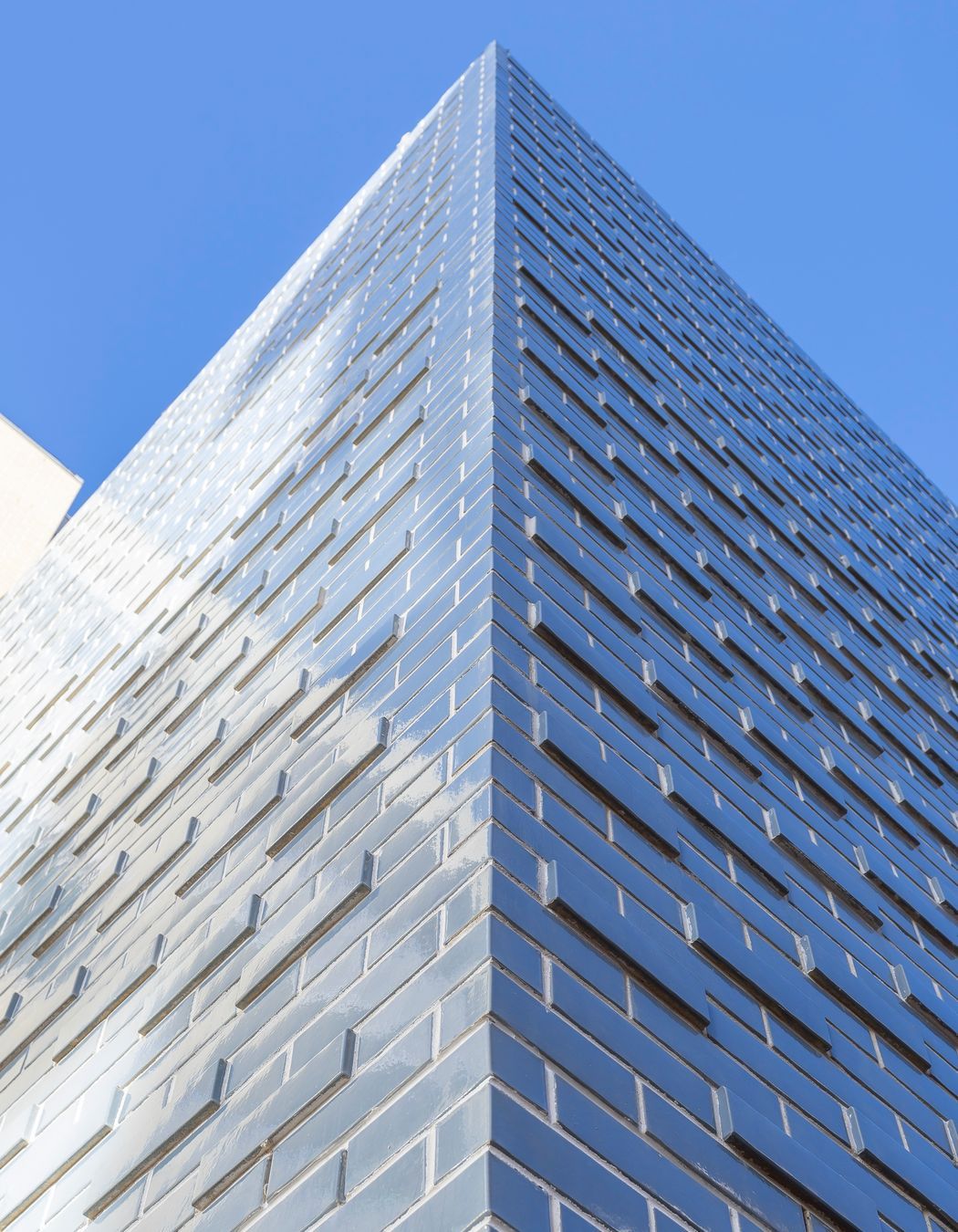 The glazed brick façade shimmers in the sunlight.