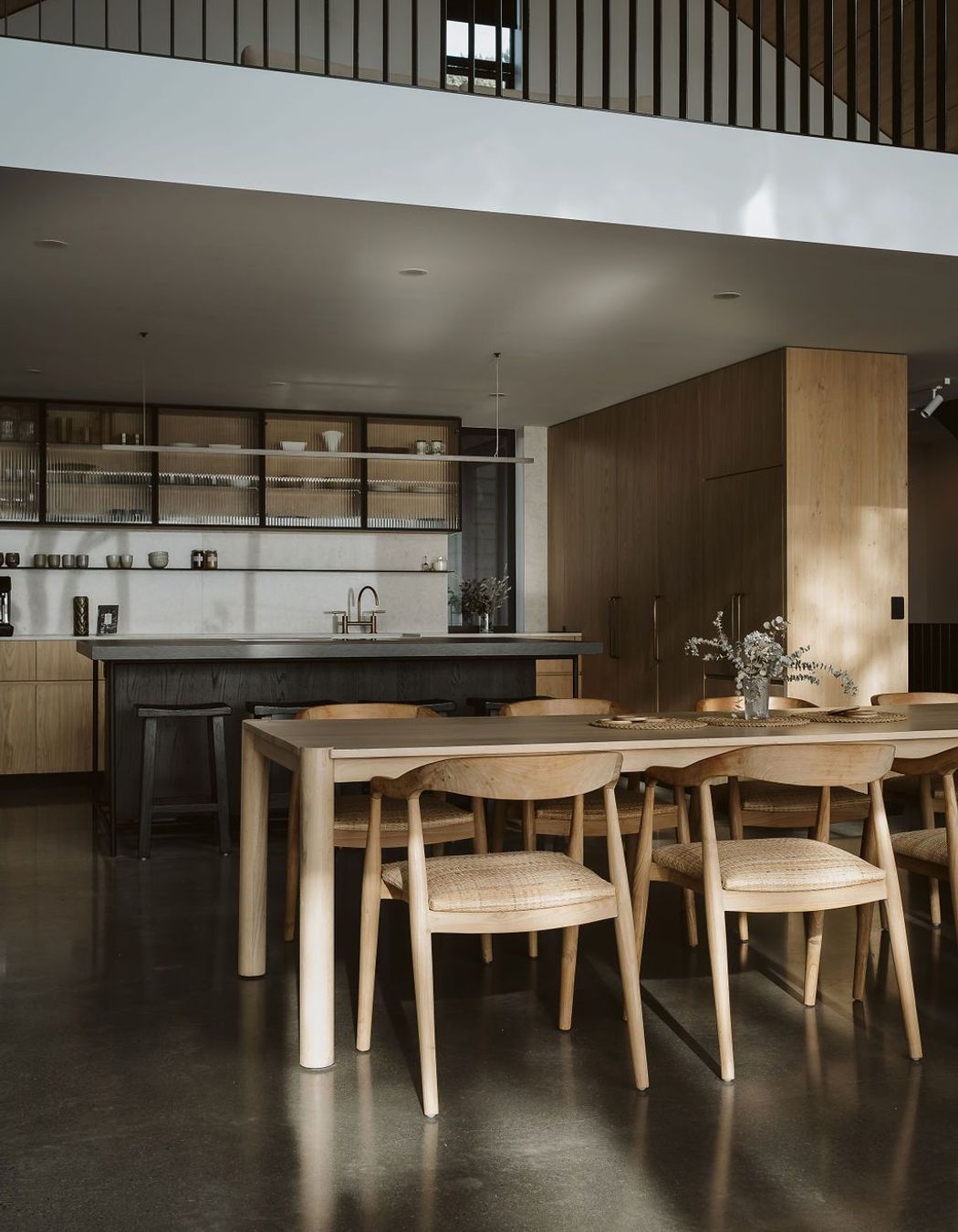 The kitchen was designed, manufactured and installed by Glen John Kitchens and features hardwood cabinetry with fluted glass, a dark stained island bench and an open-plan design that connects with the dining area.