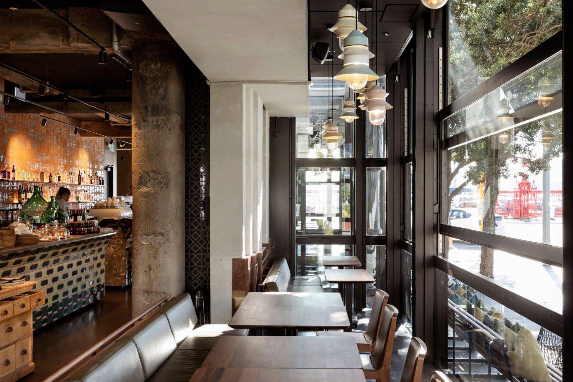 A group of small pendant lights create warmth in the dining space, without overwhelming the narrow area between the facade and the internal heritage wall.