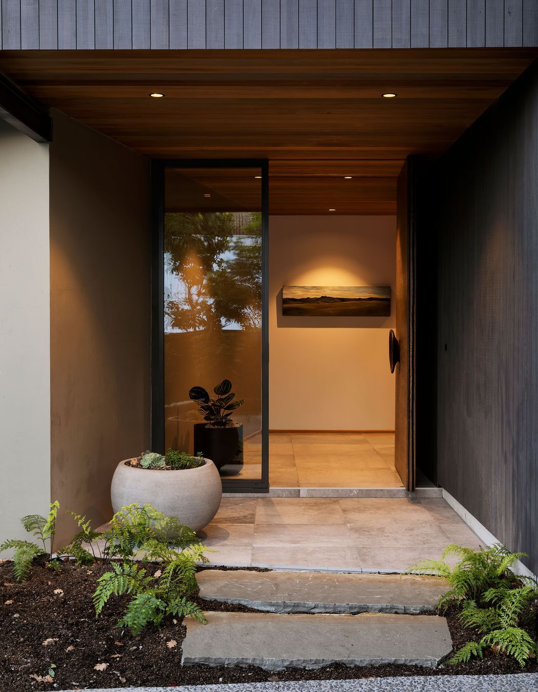 The main entrance features La Roche tiles from European Ceramics which look like polished concrete. This leads to a stairwell space which is compressed and releases you into the open living space on the level above.