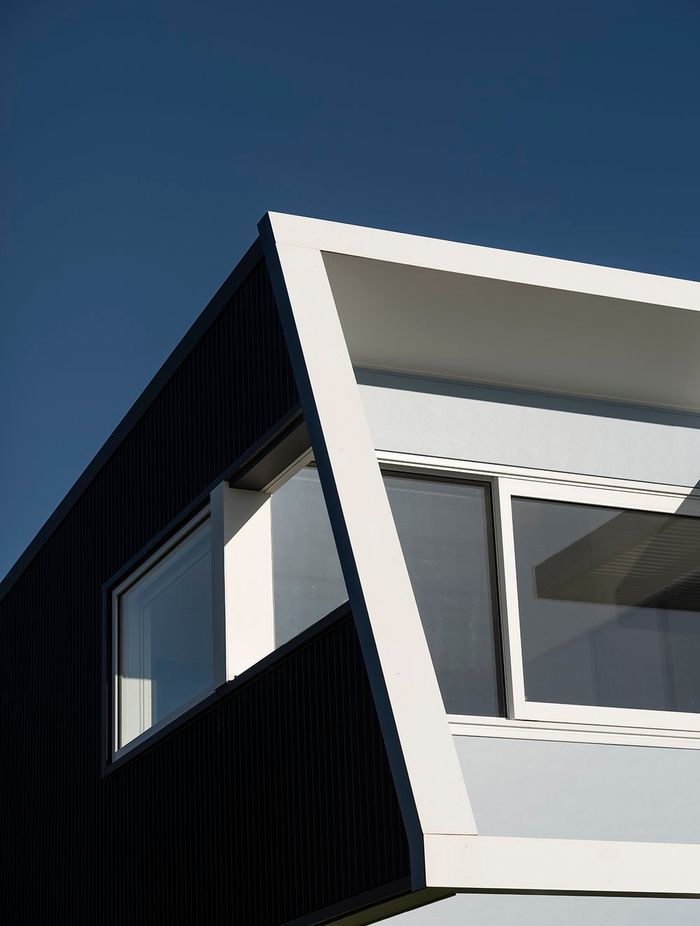 On the west, street-facing elevation, the second level protrudes over the downstairs with an elevated deck and pergola, creating shade and protection from the prevailing wind on both levels.