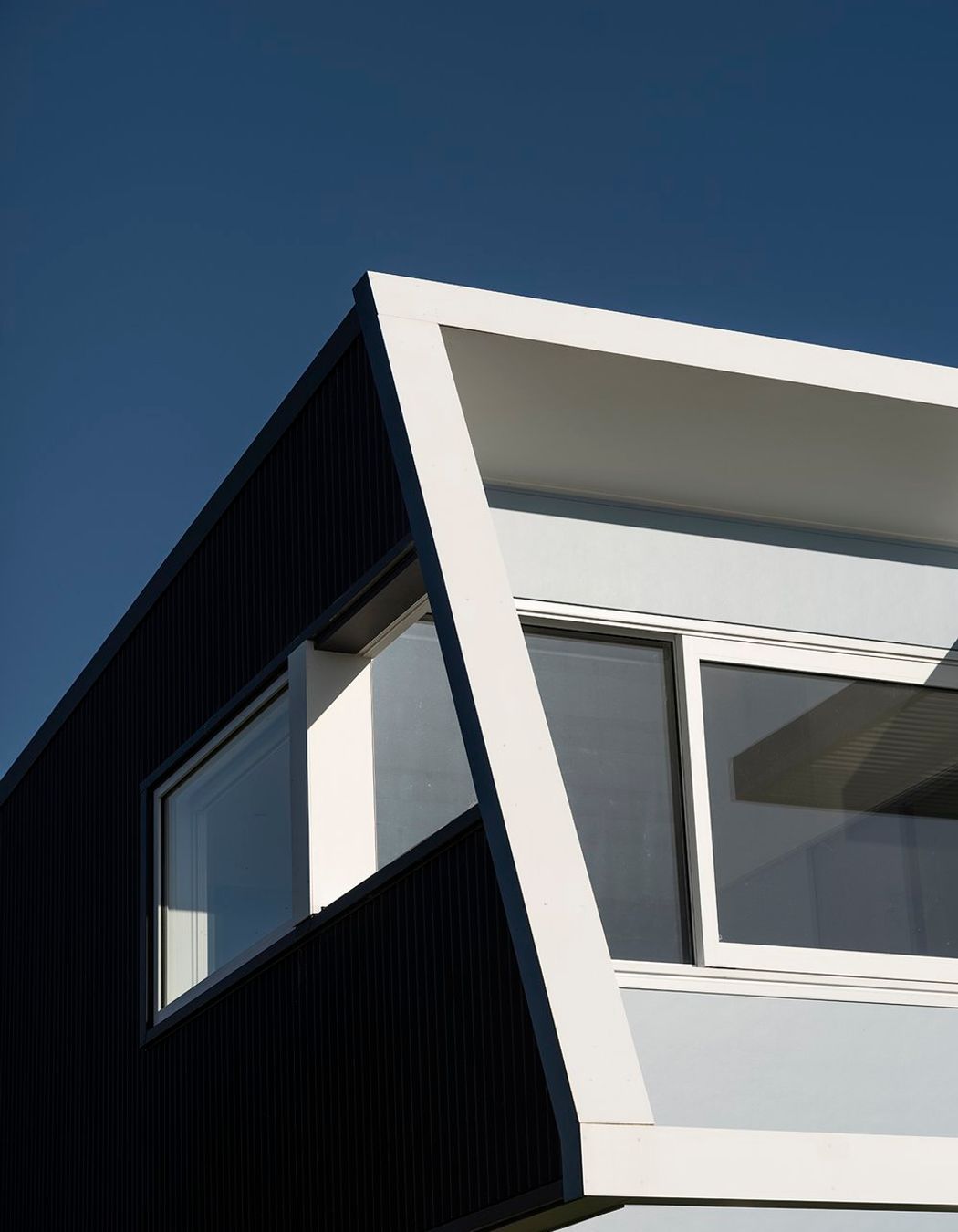 On the west, street-facing elevation, the second level protrudes over the downstairs with an elevated deck and pergola, creating shade and protection from the prevailing wind on both levels. 