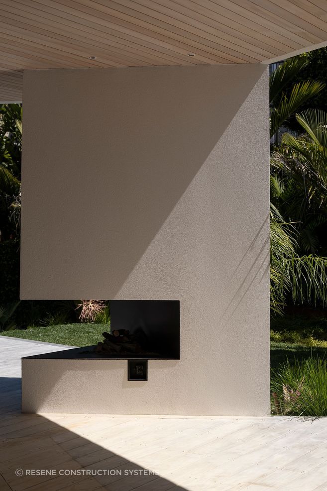 The irregular triangle design of the outdoor fireplace showcases the beauty of the crisp plaster finish.