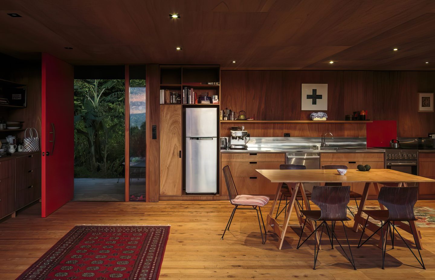 The open-plan living room is anchored only by the kitchen bench at the back and small log fire at one end.