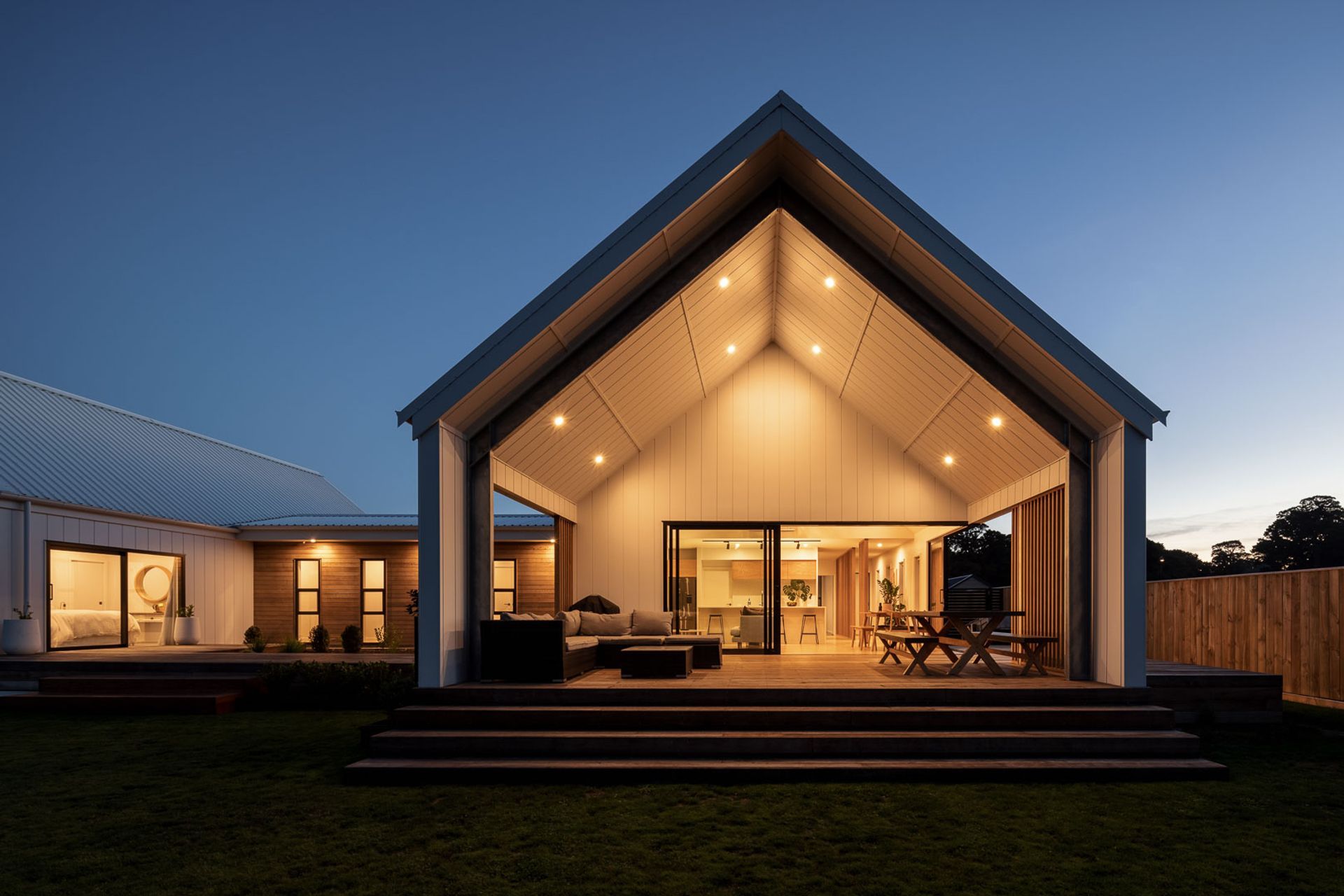The magnificence of the gabled pavilions and contrasting use of weatherboards can still be appreciated at dusk with its excellent outdoor lighting design. | Photography: André Vroon Photographer