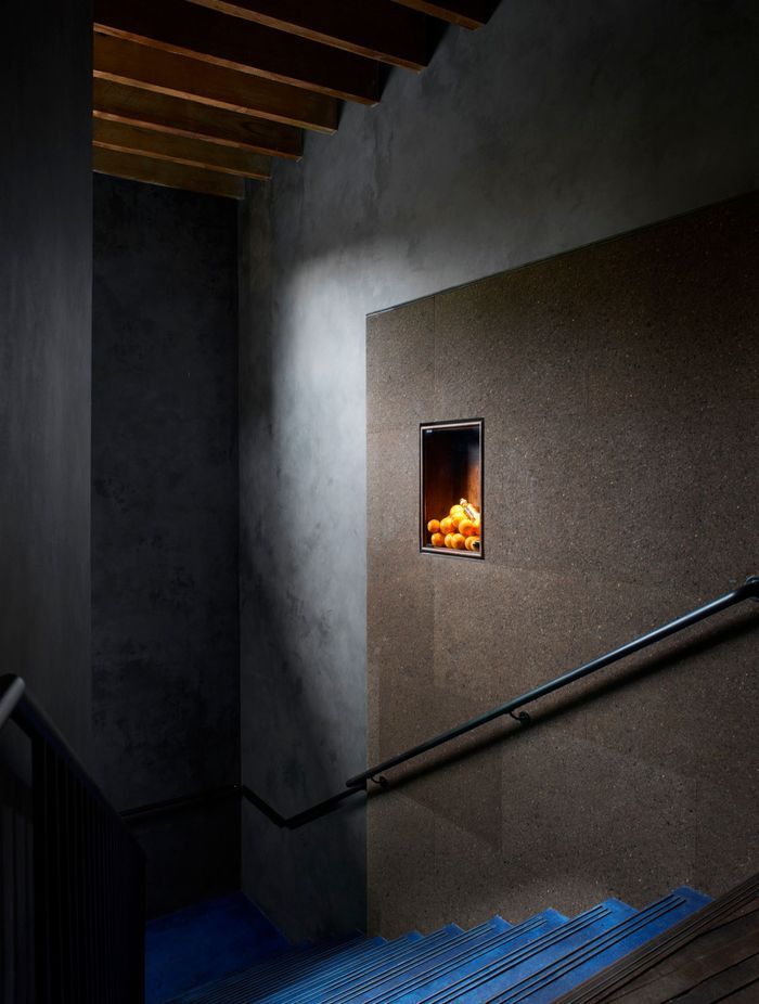 Clad in charcoal Portuguese cork panels, the staircase wall leading to the Gin Lab provides acoustics and internal advertising needs in one, thanks to its pin-able surface.