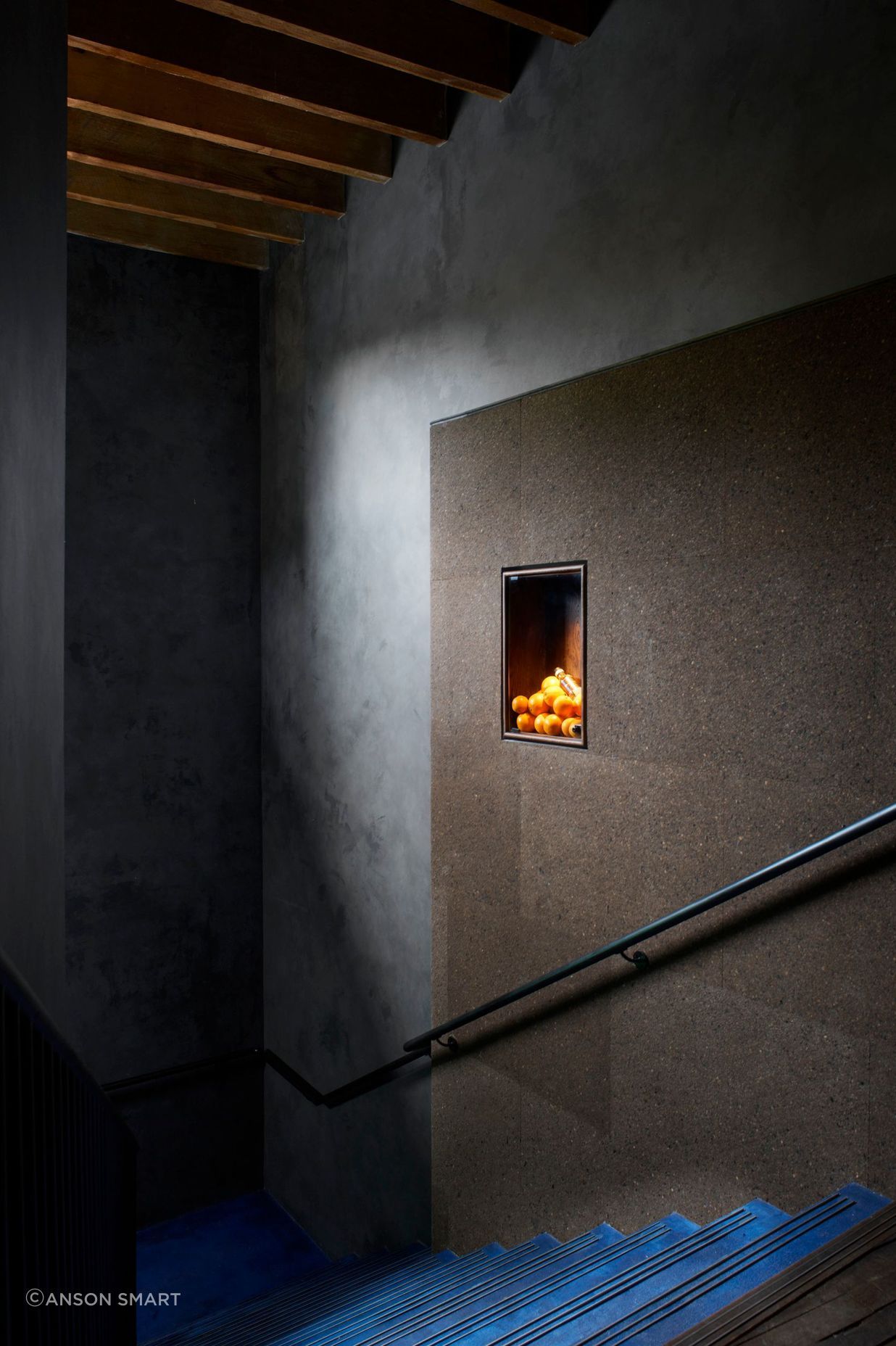Clad in charcoal Portuguese cork panels, the staircase wall leading to the Gin Lab provides acoustics and internal advertising needs in one, thanks to its pin-able surface.