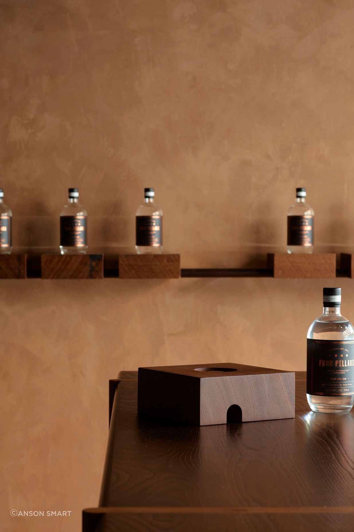 Grooved solid timber blocks with a range of gin bottles can be removed from their metal rail base; instantly converting the store to a cellar door.