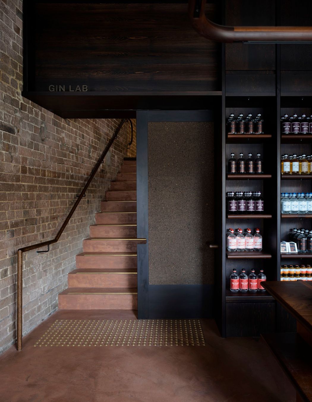 Micro-cement rendered walls and floors with a Pandomo finish add a rustic vibe with a nod to the Four Pillars’ copper-toned logo.