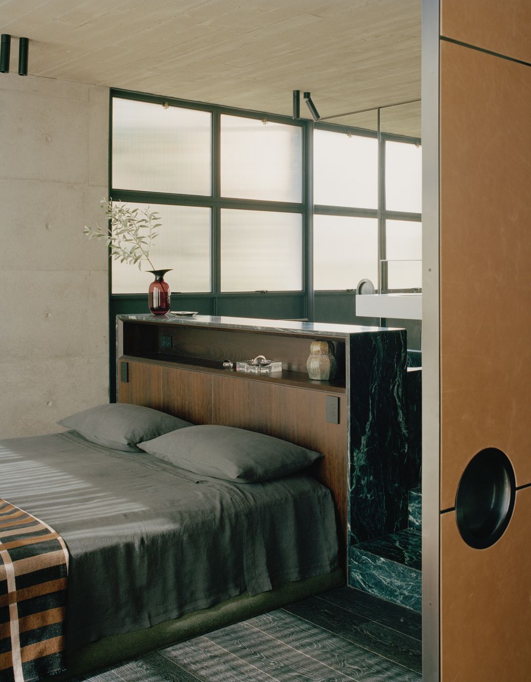 In the master bedroom, the bedhead is formed by the back of the marble bath.