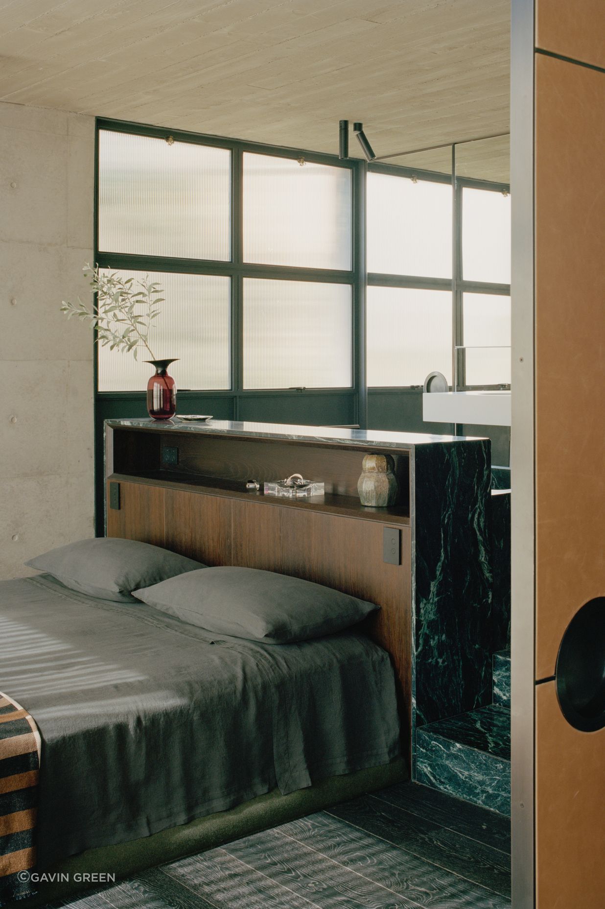 In the master bedroom, the bedhead is formed by the back of the marble bath.