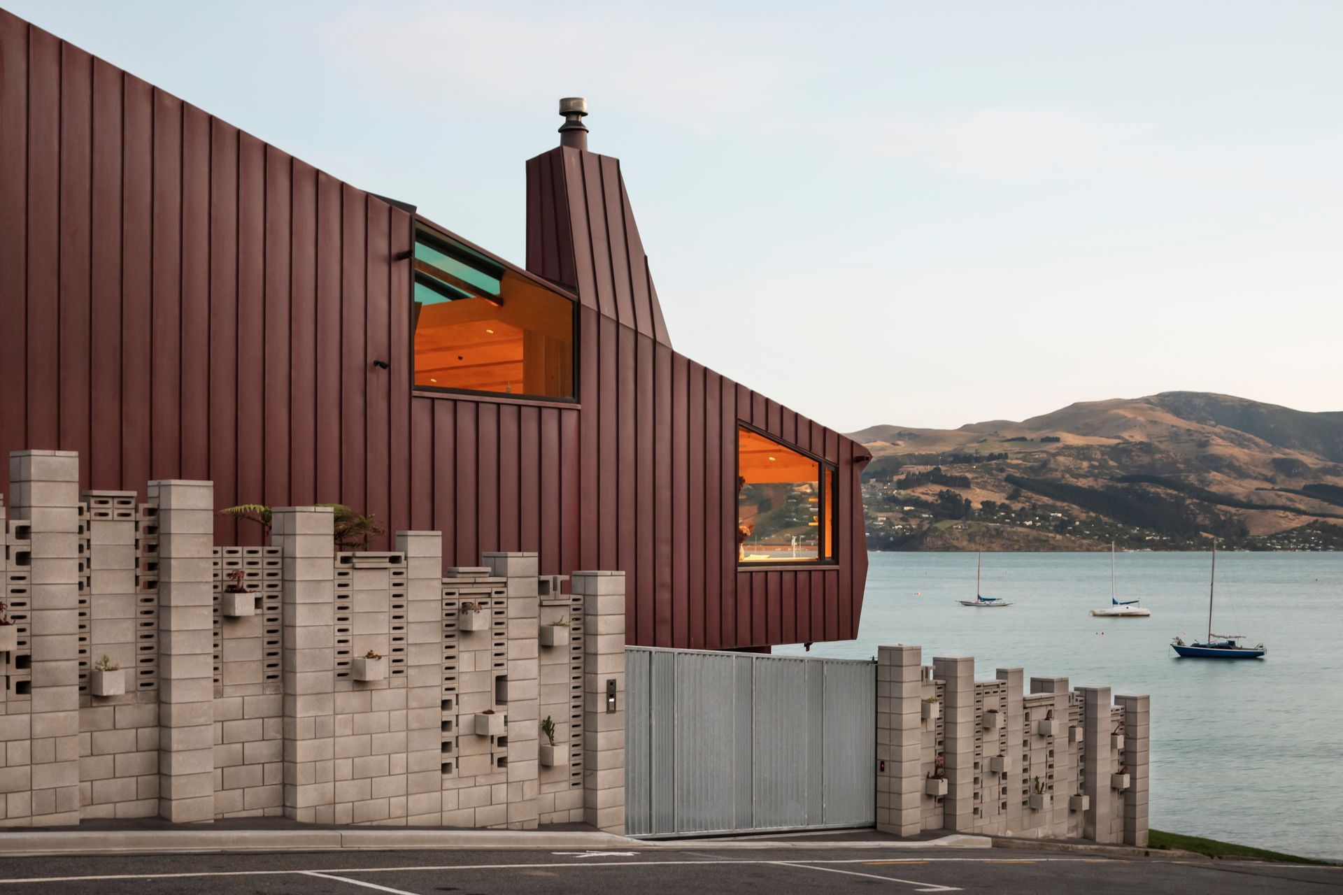 The skylight allows light into the living room area, but also provides views out to the bay from the mezzanine master bedroom. “We worked on site with the builders and homeowners to come up with a chimney form that was more attractive because you were looking at it from the bedroom,” says Brad. The sculptural ViBlock masonry block wall was built to provide privacy from the public car parking by the beach.