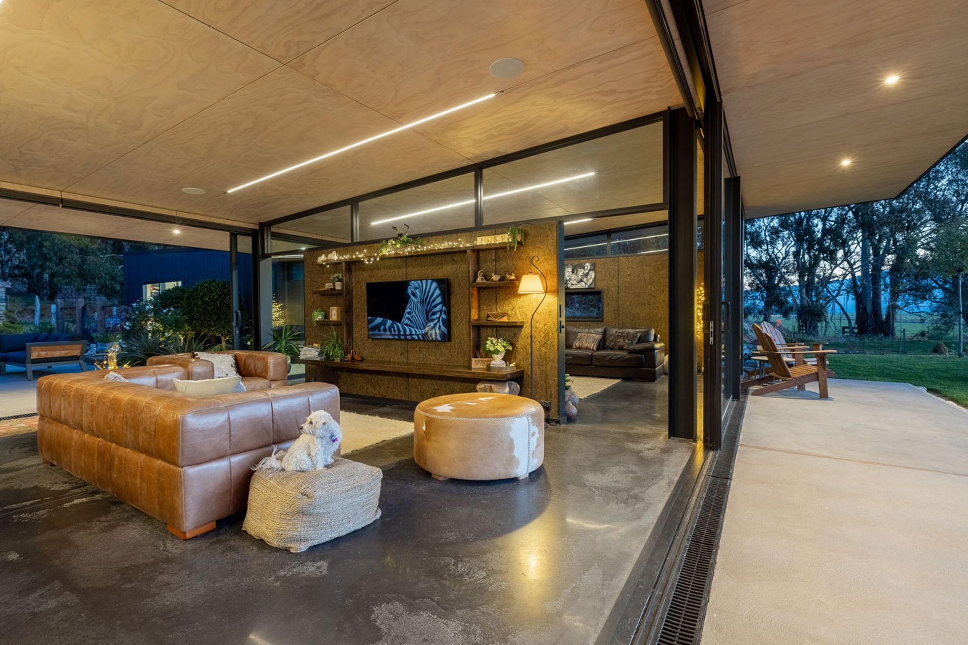 The dividing wall creates two living spaces while retaining the open-plan flow. Strip lighting in the ceiling is a departure from typical downlighting, says Gary. It complements the lines of the ceiling during the day and leads the eye outside.