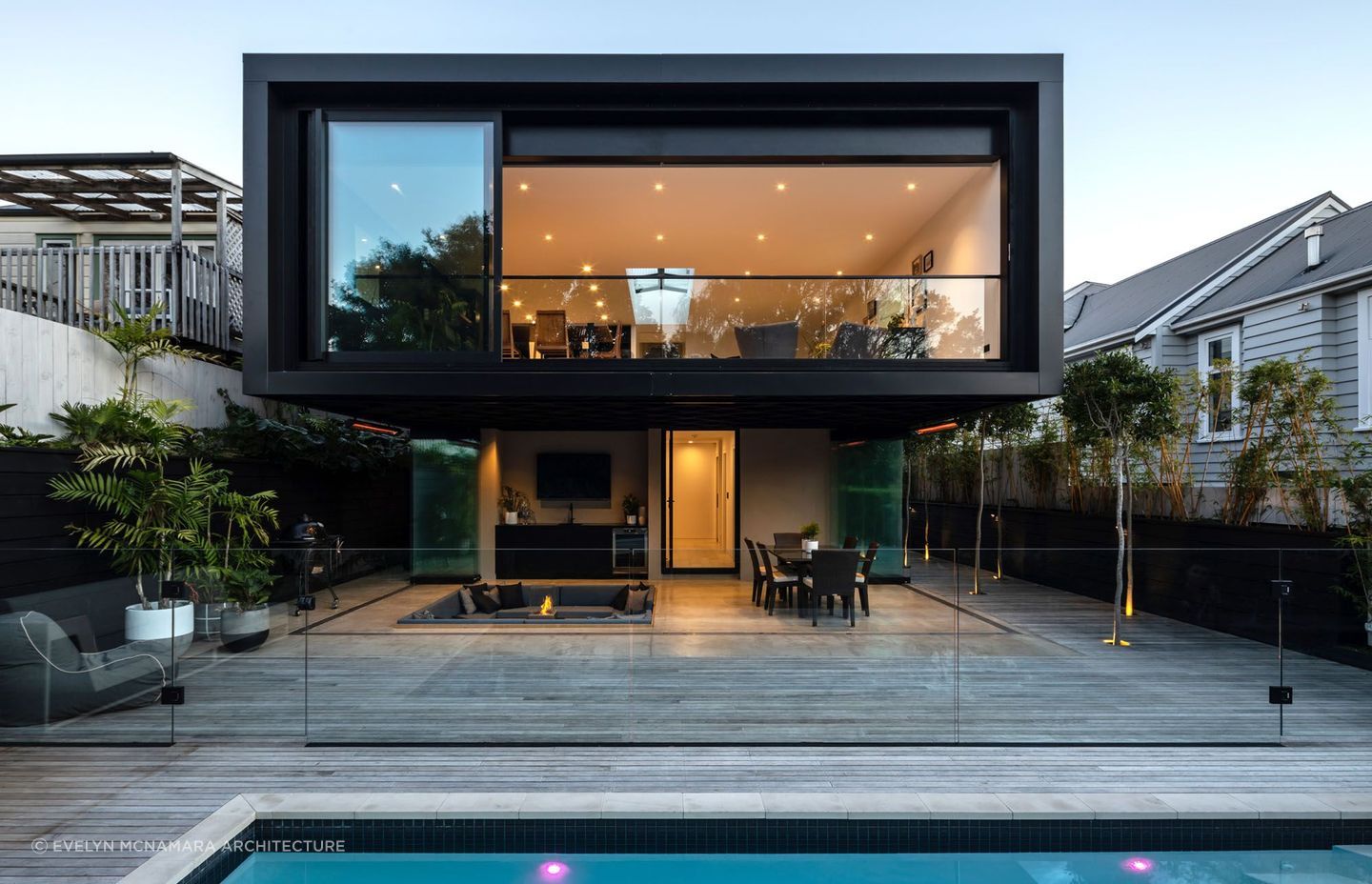 The exterior and outdoor living space featuring a pool, sunken lounge, firepit and outdoor kitchen. | Photography: Jono Parker