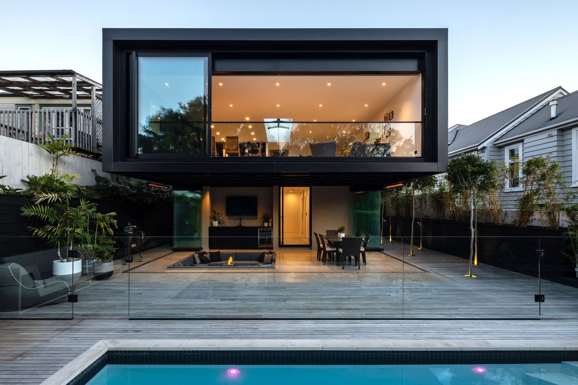 The exterior and outdoor living space featuring a pool, sunken lounge, firepit and outdoor kitchen. | Photography: Jono Parker