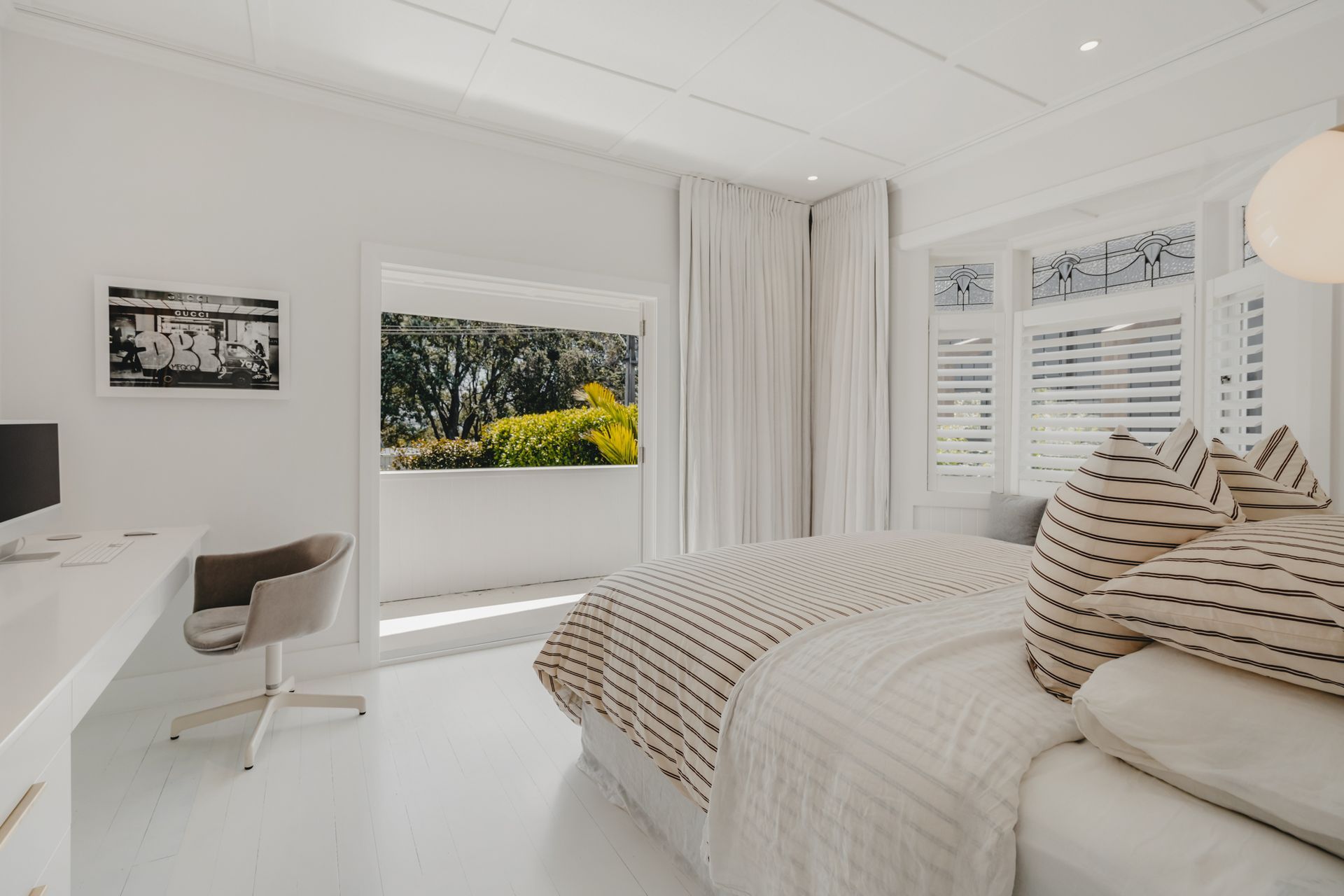 The master bedroom now features a built-in office space and floor-to-ceiling drapes.