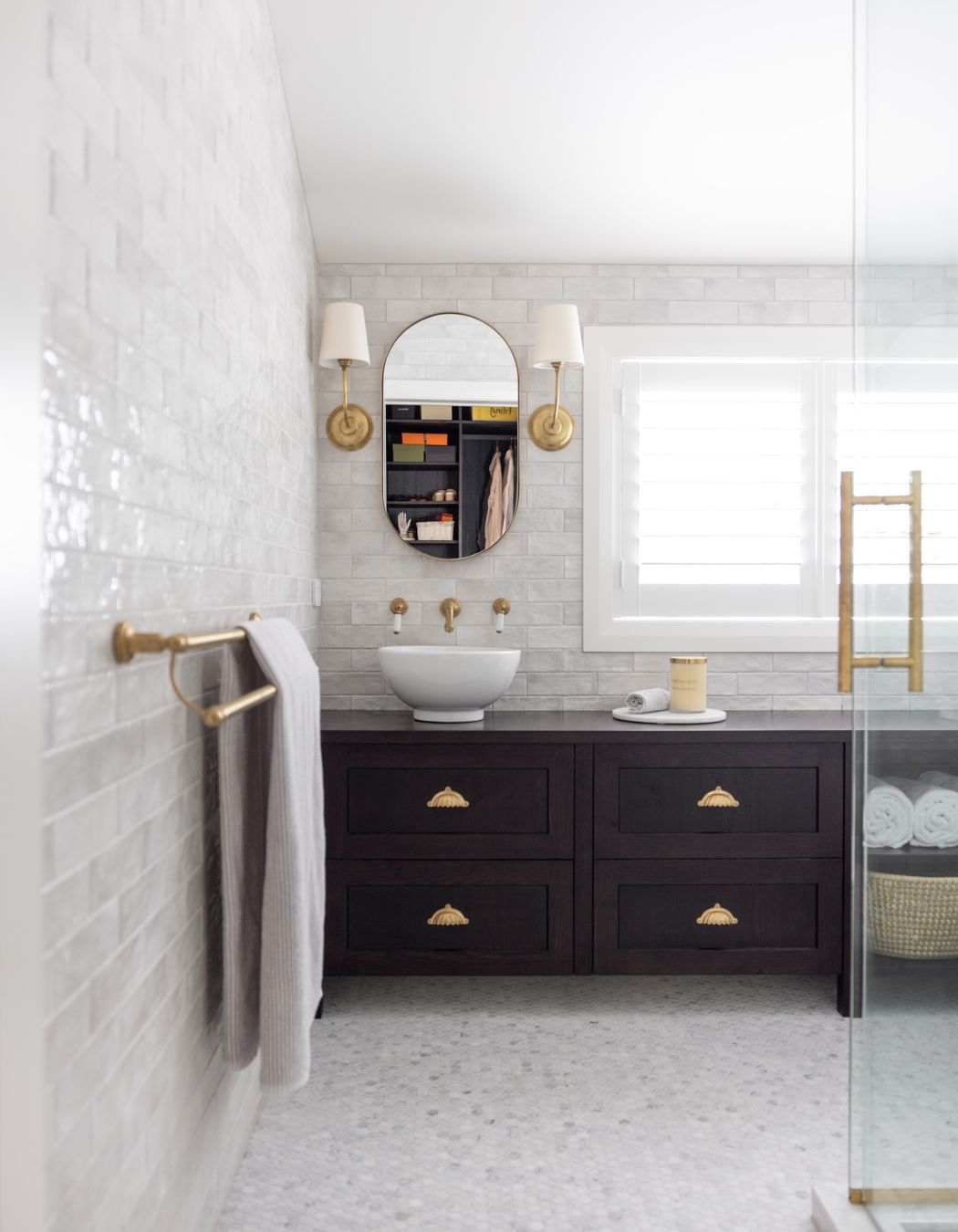 The ensuite feels bright and open, with glossy white subway tiles adding a hint of texture to the walls.