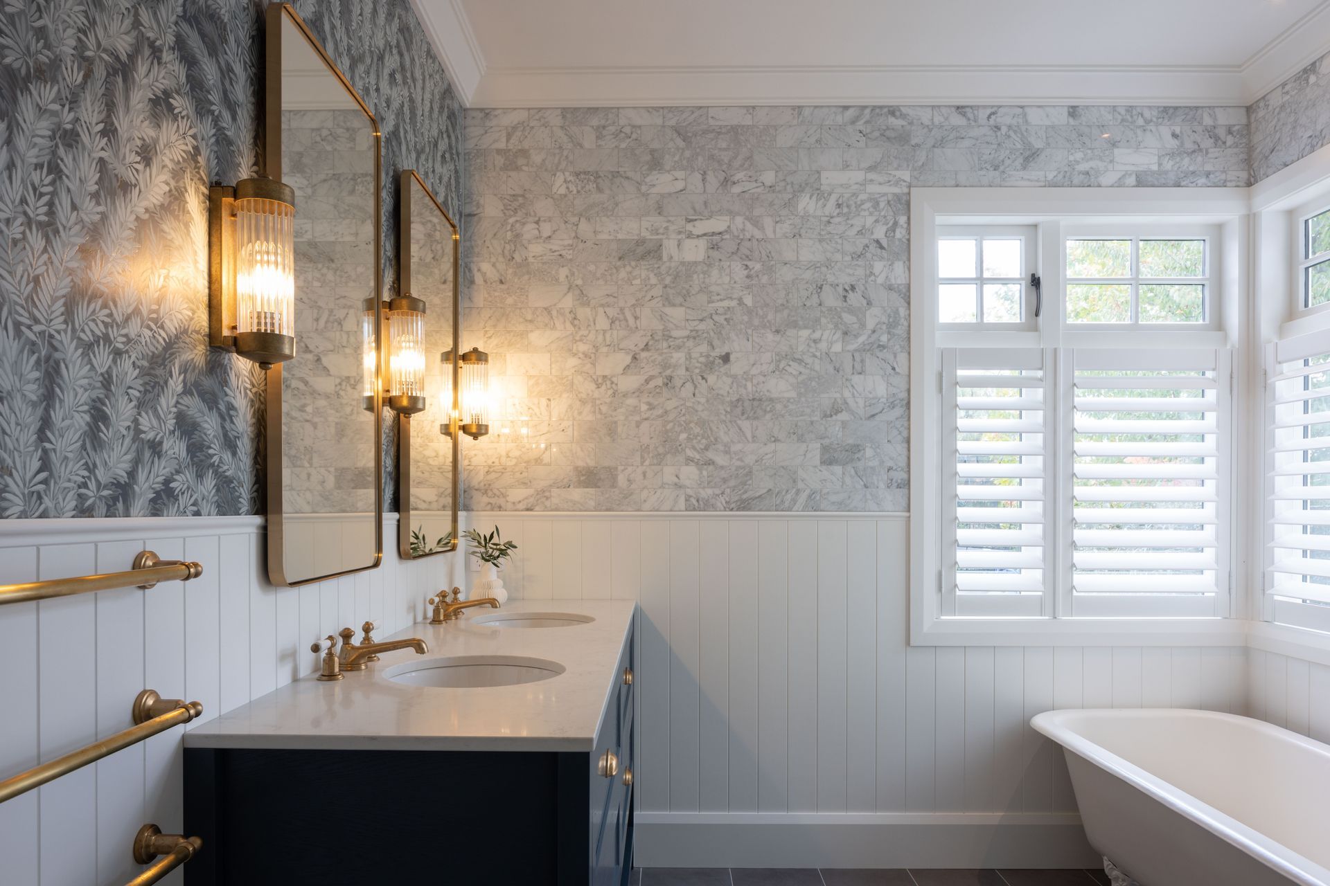 The hotel-like feel continues in the bathrooms, with elegant sconces, a clawfoot tub, and gold fixtures.