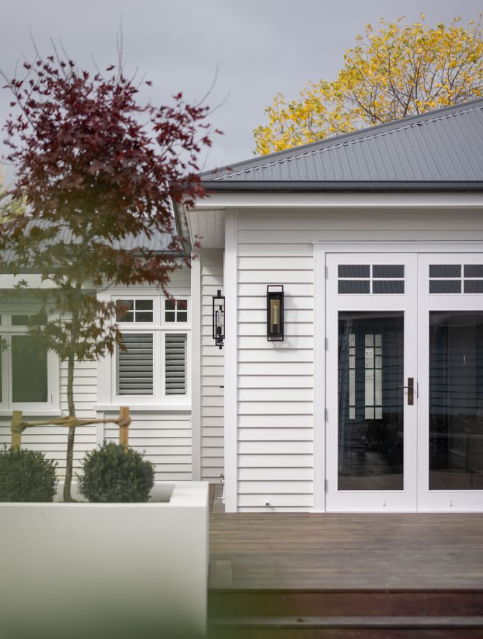 The open-plan living area connects to the deck and backyard through glazed doors.