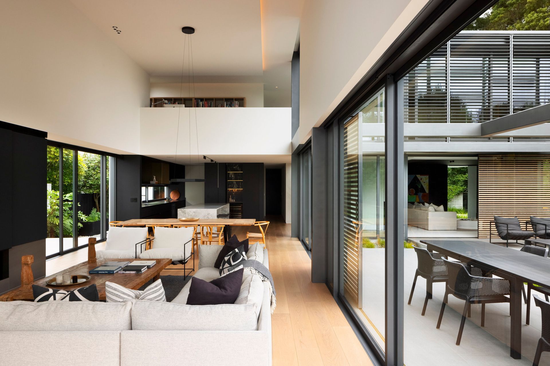Upstairs, a mezzanine level with a study overlooks the double-height living area.