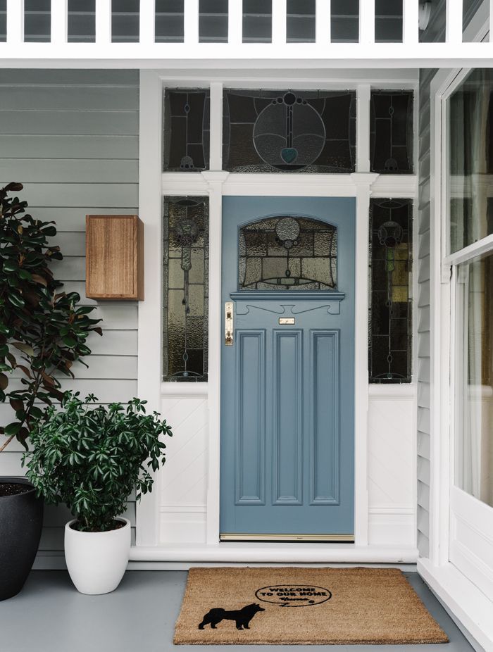 The original front door with stained glass has been refreshed with a coat of pale French blue paint.
