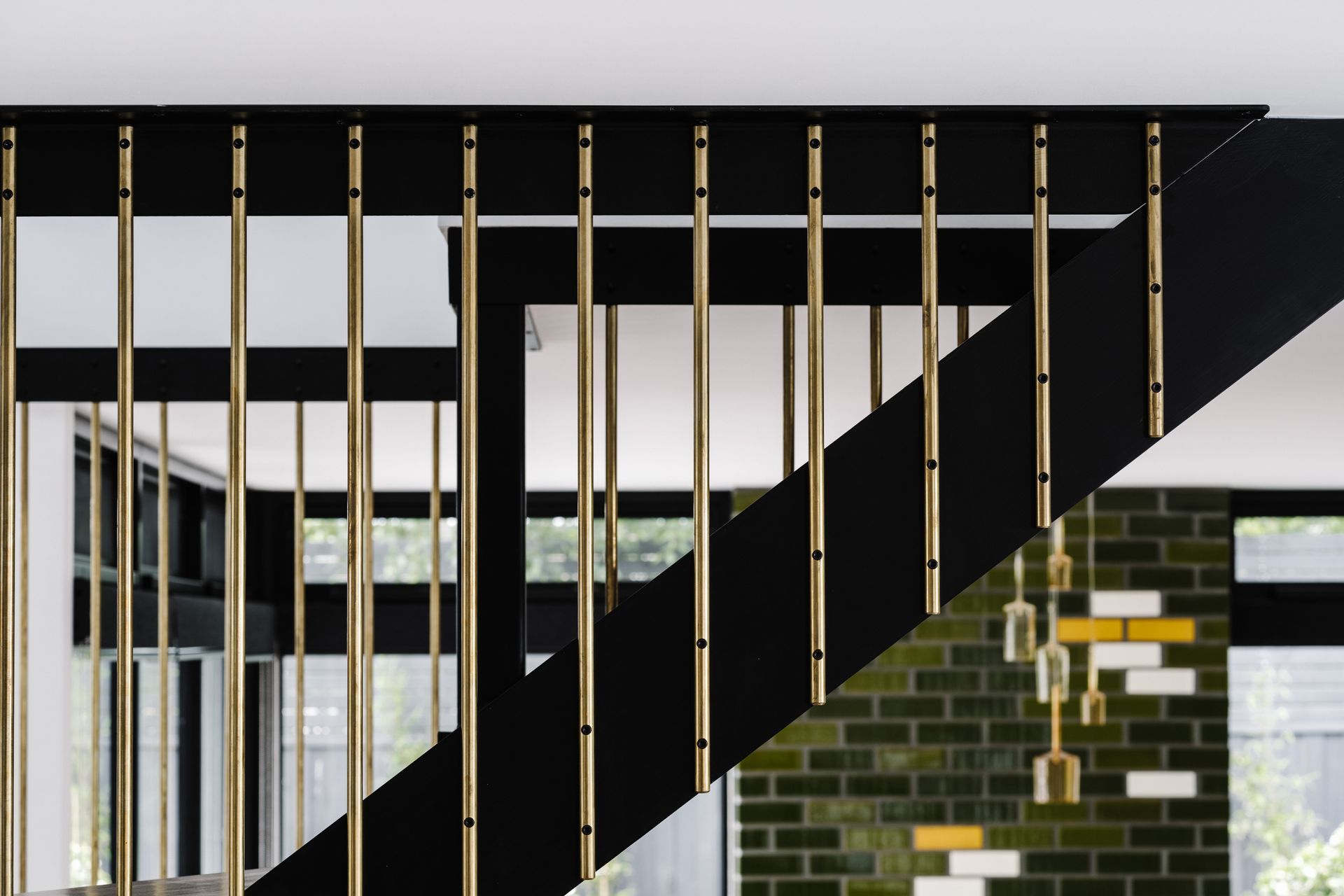 The staircase is a solid steel black structure with messmate steps, a Victorian ash handrail and custom brass rod balustrades.