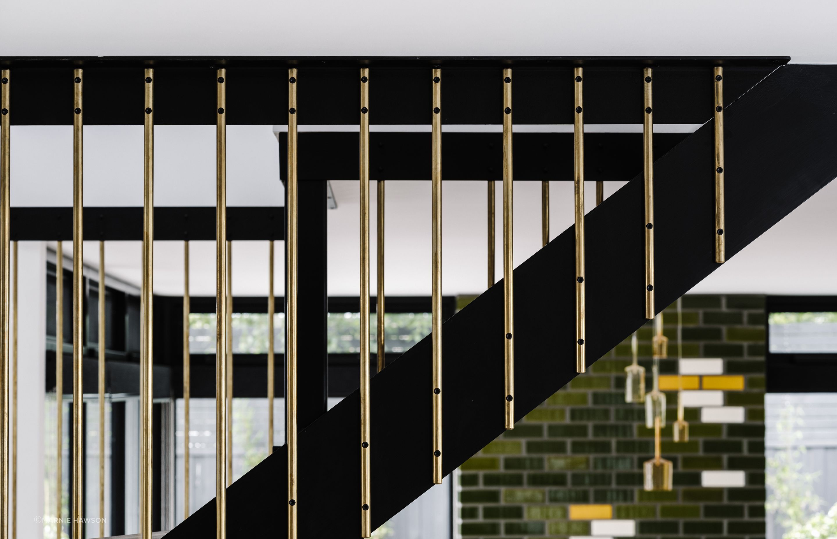 The staircase is a solid steel black structure with messmate steps, a Victorian ash handrail and custom brass rod balustrades.