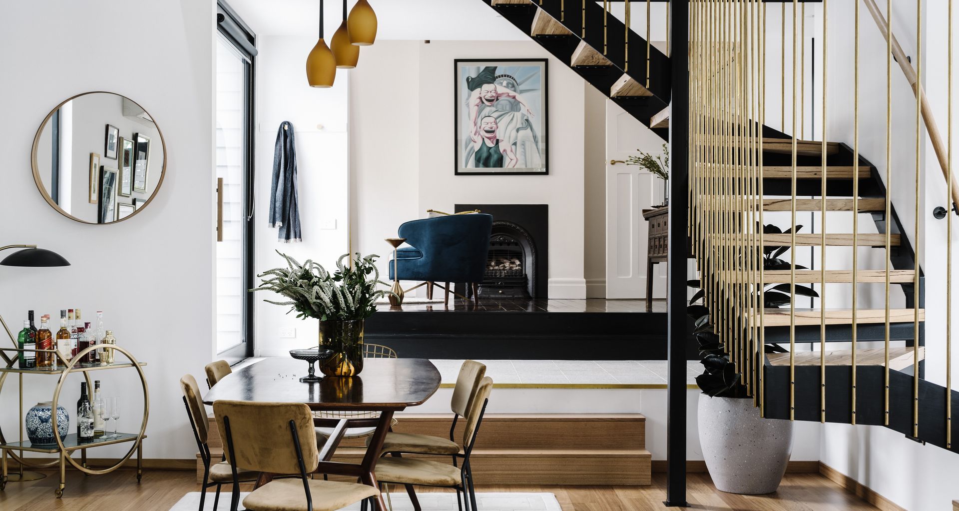 A large glass pivot door serves as a side entrance, welcoming guests directly where the original home meets the new extension. A seating area drops down to the lounge and dining. Image credit: Marnie Hawson