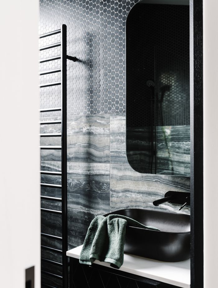 The master ensuite is a contrast to the main bathroom with its dark, masculine colour palette.