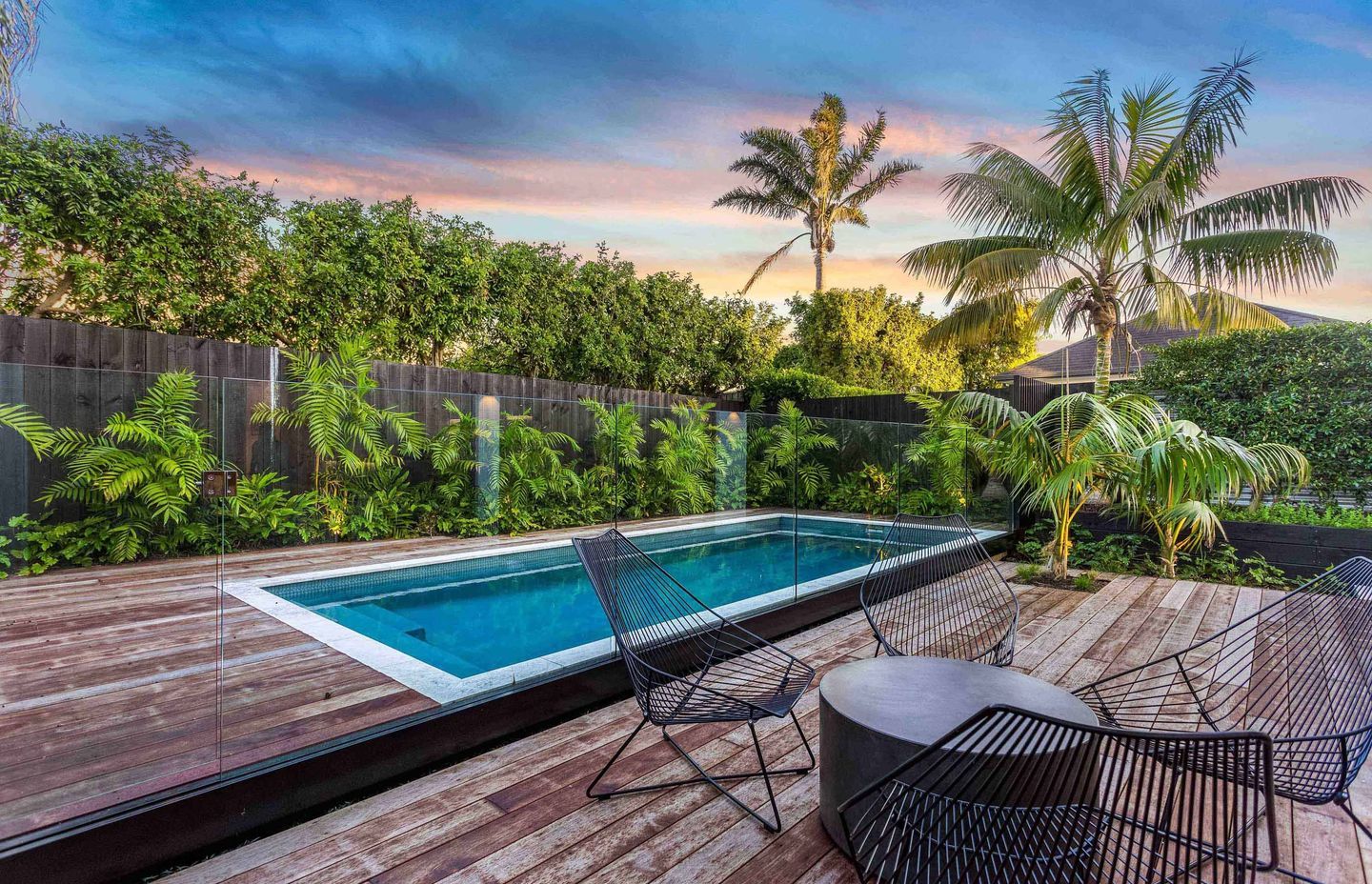 The pool area is enclosed by Kwila decking and generous semi-tropical planting to soften the edges.
