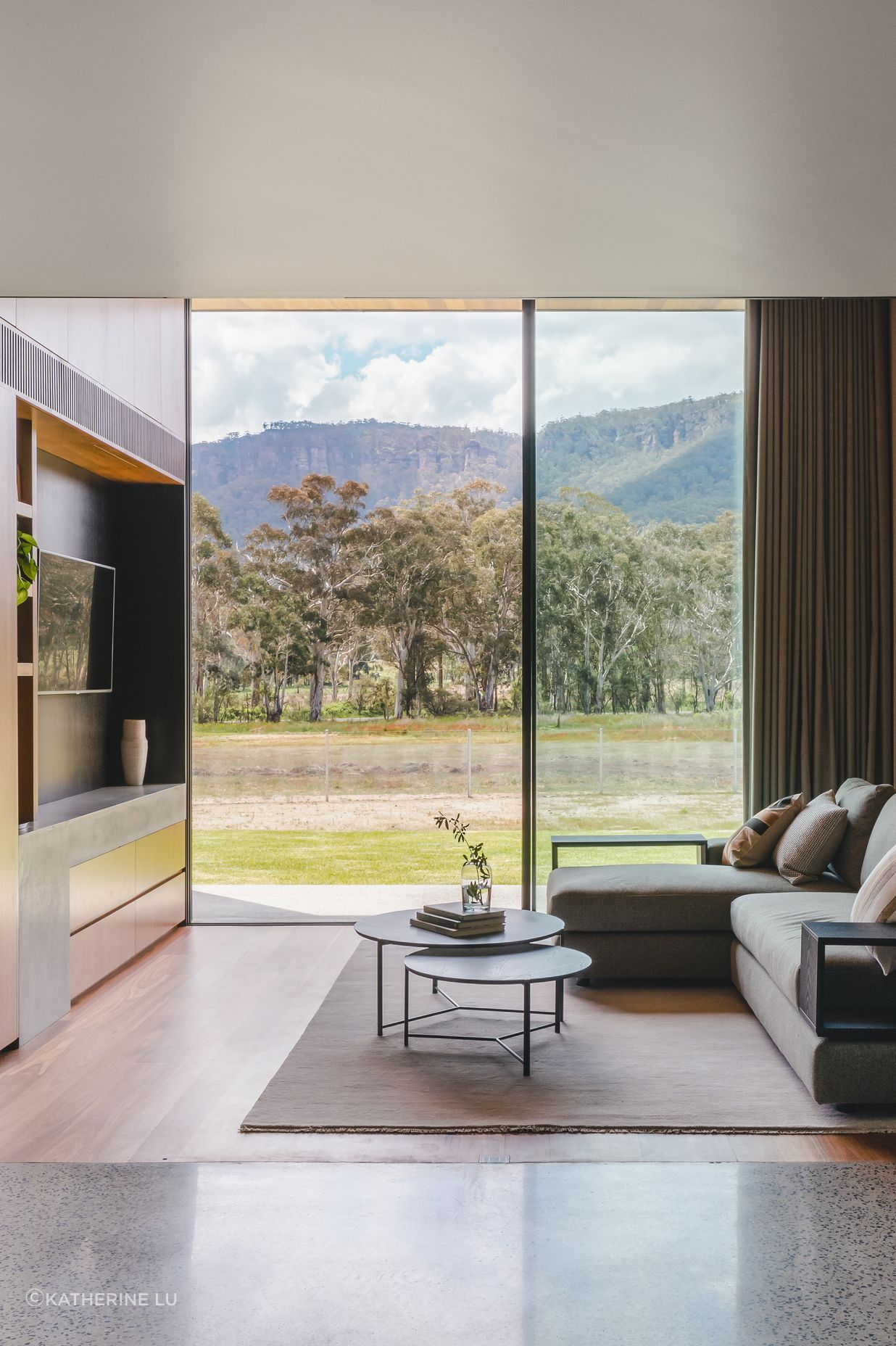 Floor to ceiling glass captures the dense bushland and mountains.