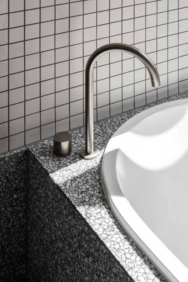 Minimalist hardware allows the tiling and stoneware to shine.