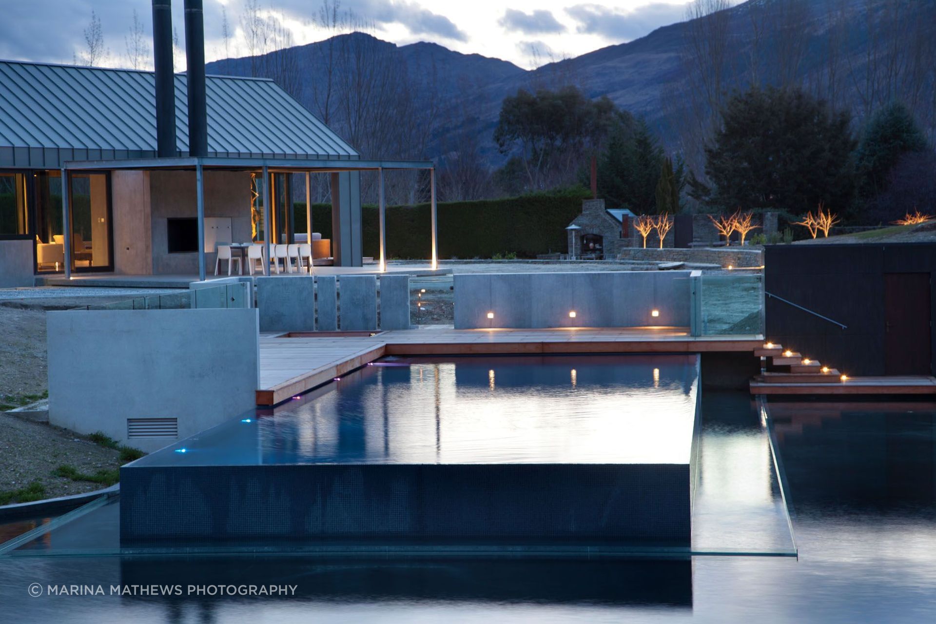 The pool spills over on three sides, running into the pond below.