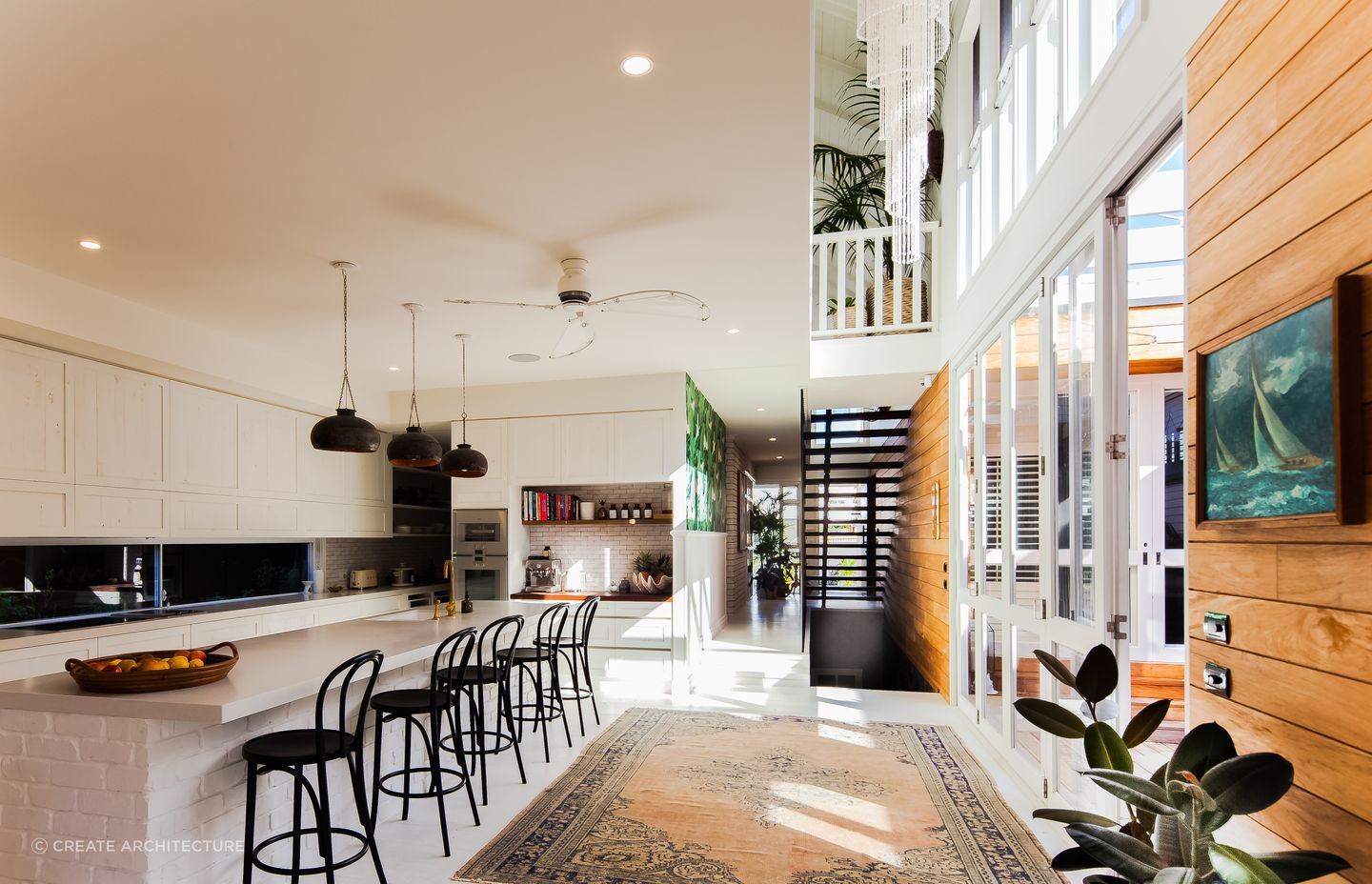 The kitchen island serves as a sturdy centrepiece, beautifully complemented by the regal allure of the kitchen rug. Photography: Andy Macpherson Studio.
