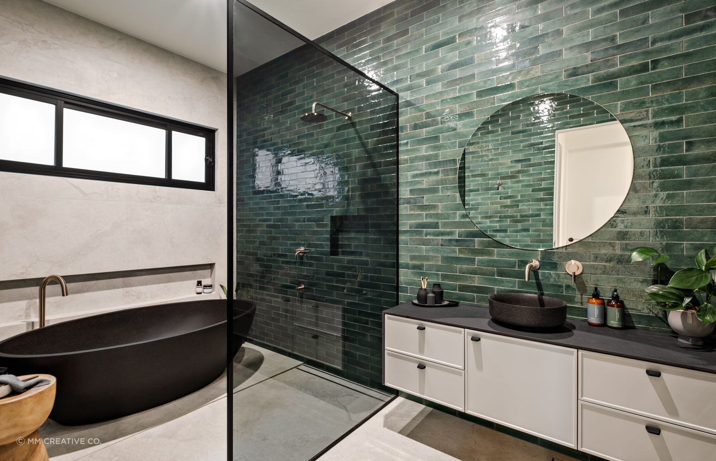 The family bathroom shared by the two younger children also features a green-tiled feature wall.