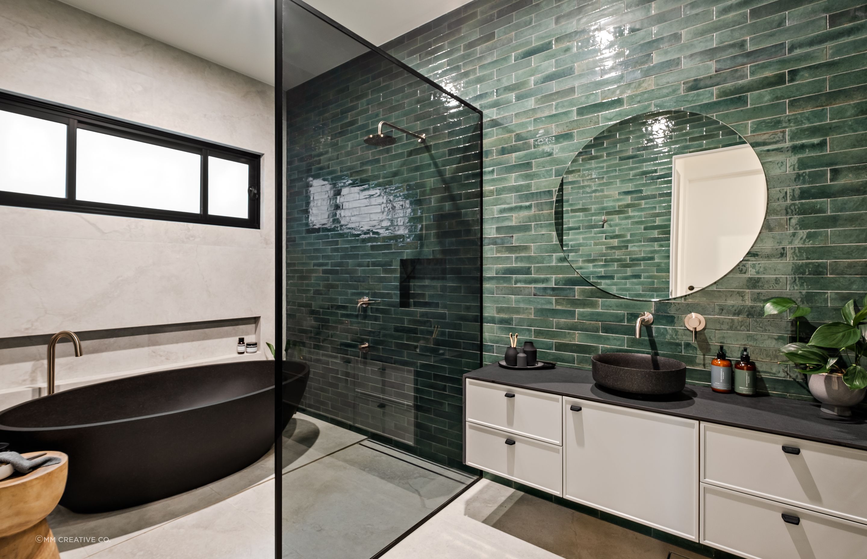 The family bathroom shared by the two younger children also features a green-tiled feature wall.