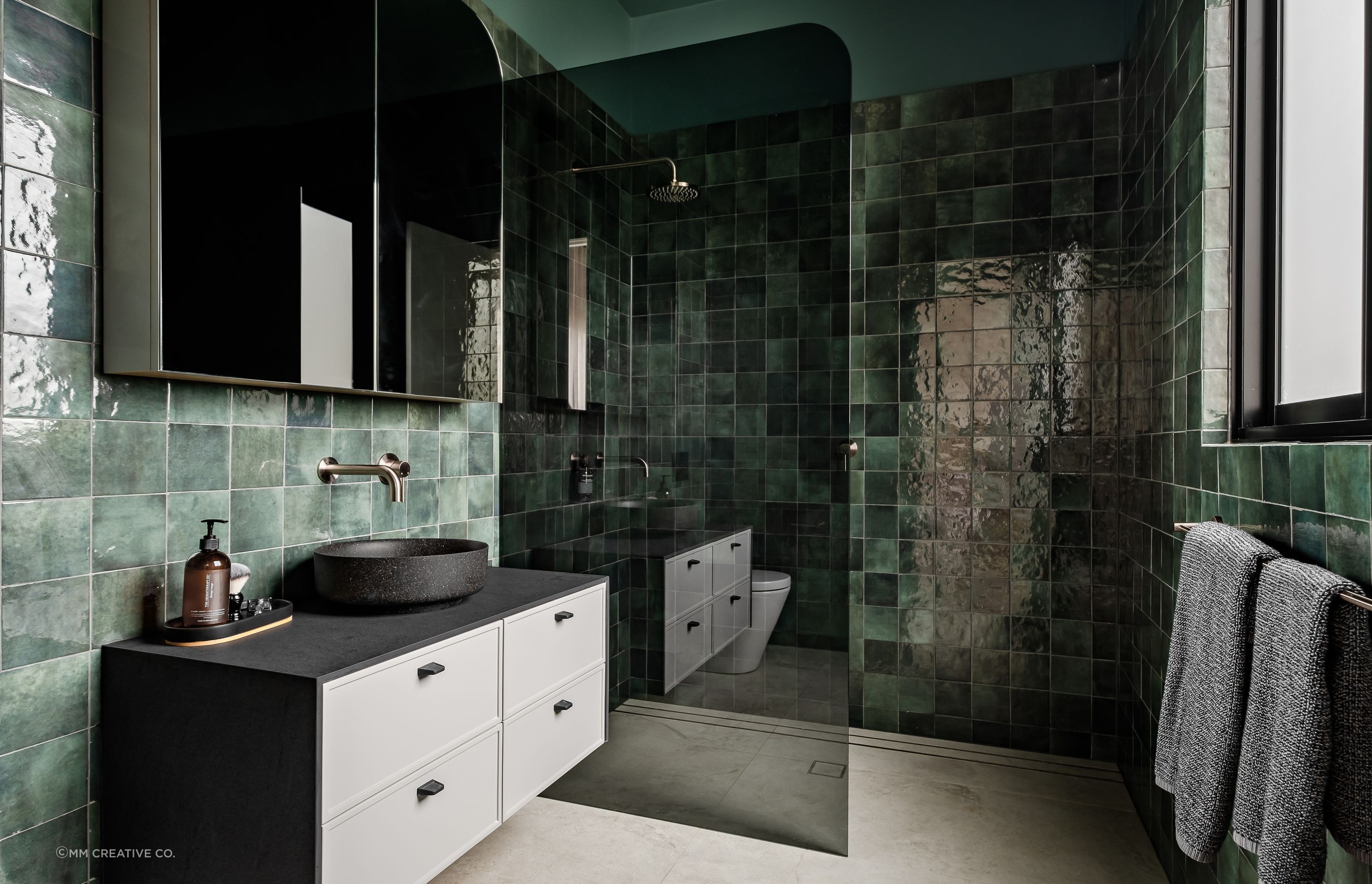 The green tiles in the bathroom create a rich and luxury palette and were chosen for the clients' love of green.