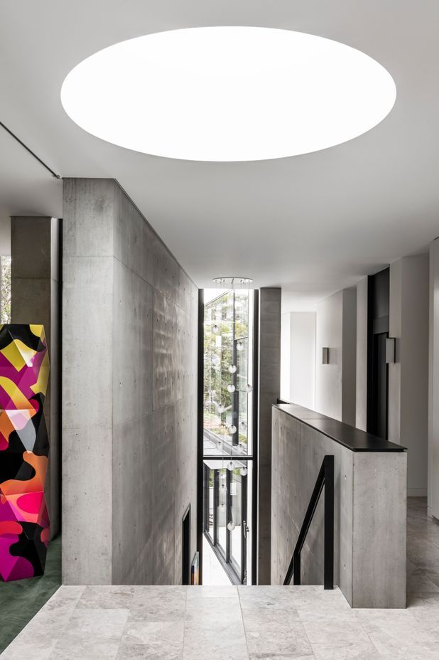 A stair running through the three storeys is spliced between the concrete blades.