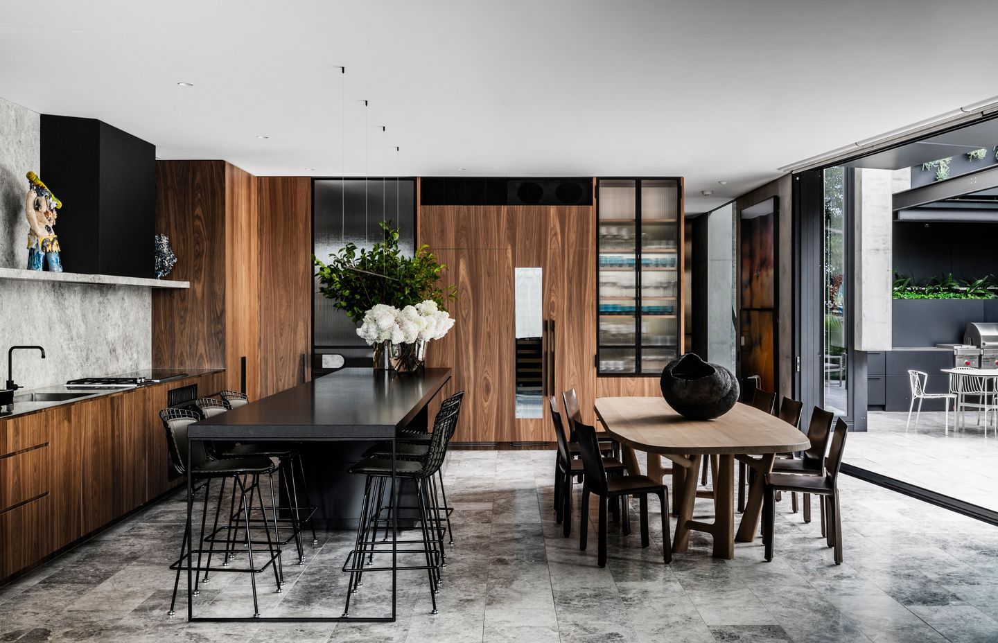 Walnut veneer cabinetry complements the concrete tones of the home beautifully, letting the objects and art add colour and texture.