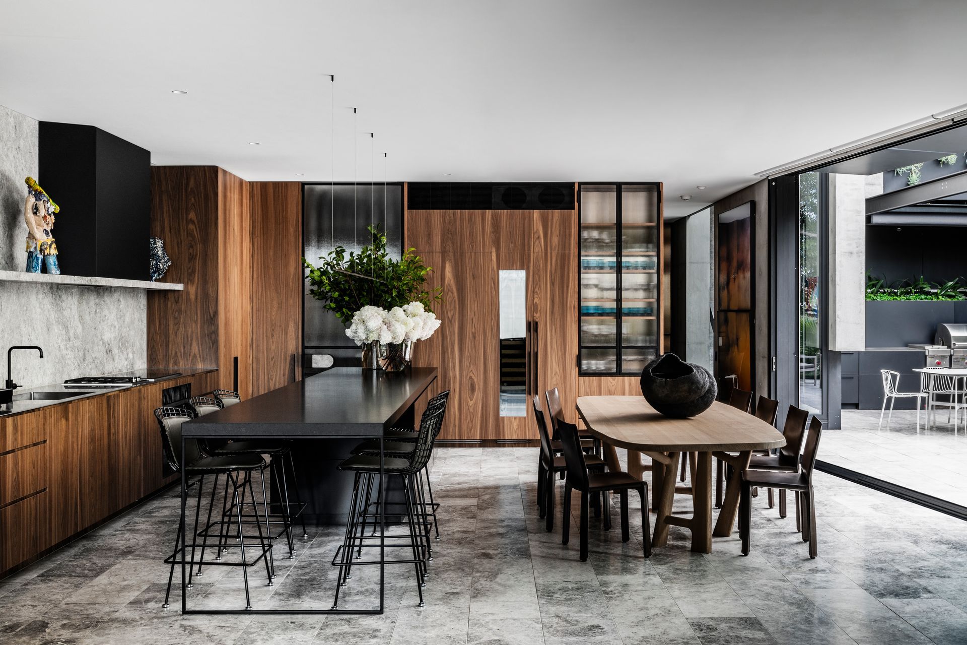 Walnut veneer cabinetry complements the concrete tones of the home beautifully, letting the objects and art add colour and texture.
