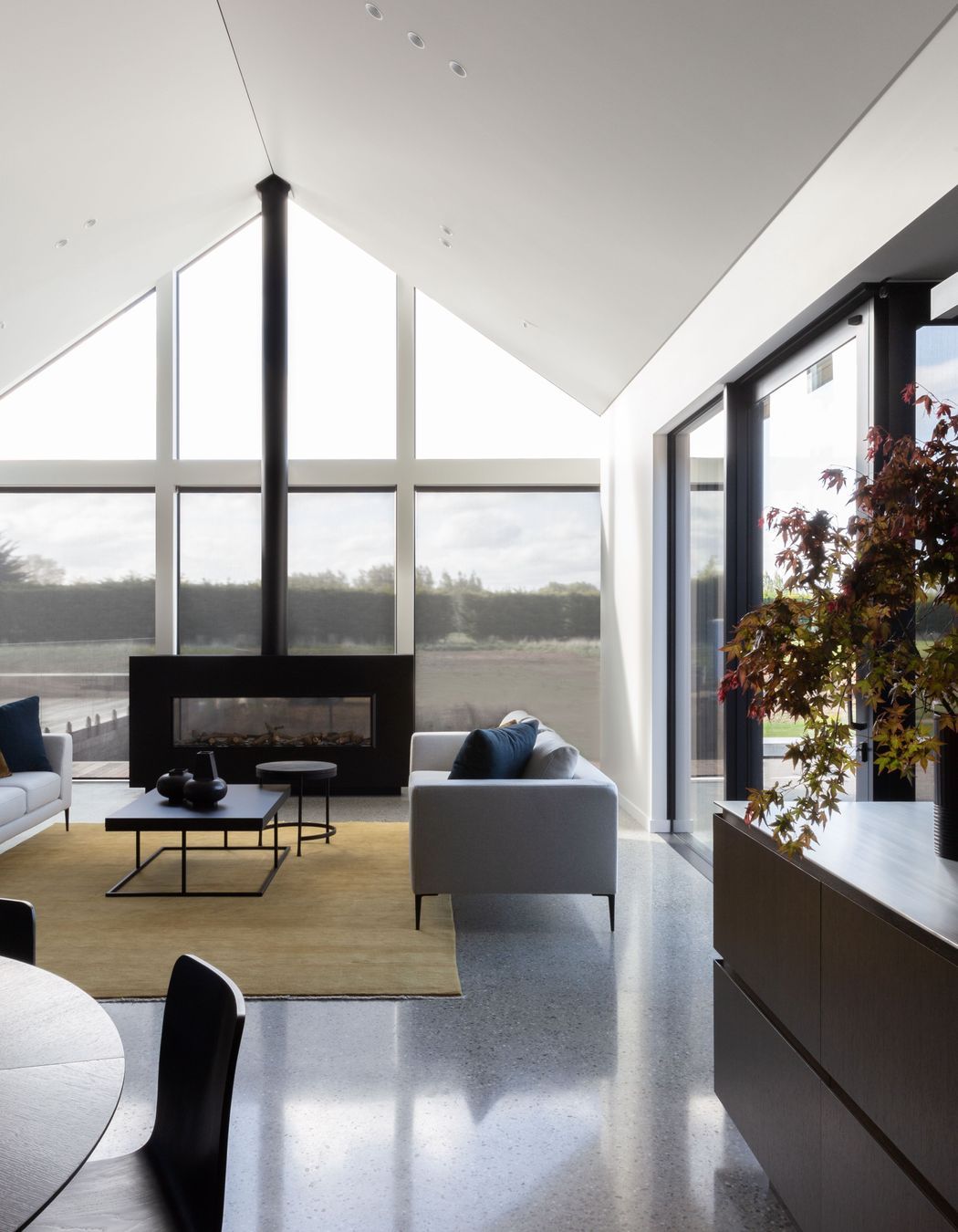 The main living room, anchored by a custom-built fireplace with a seamless flue | Photographer: Anna McLeod