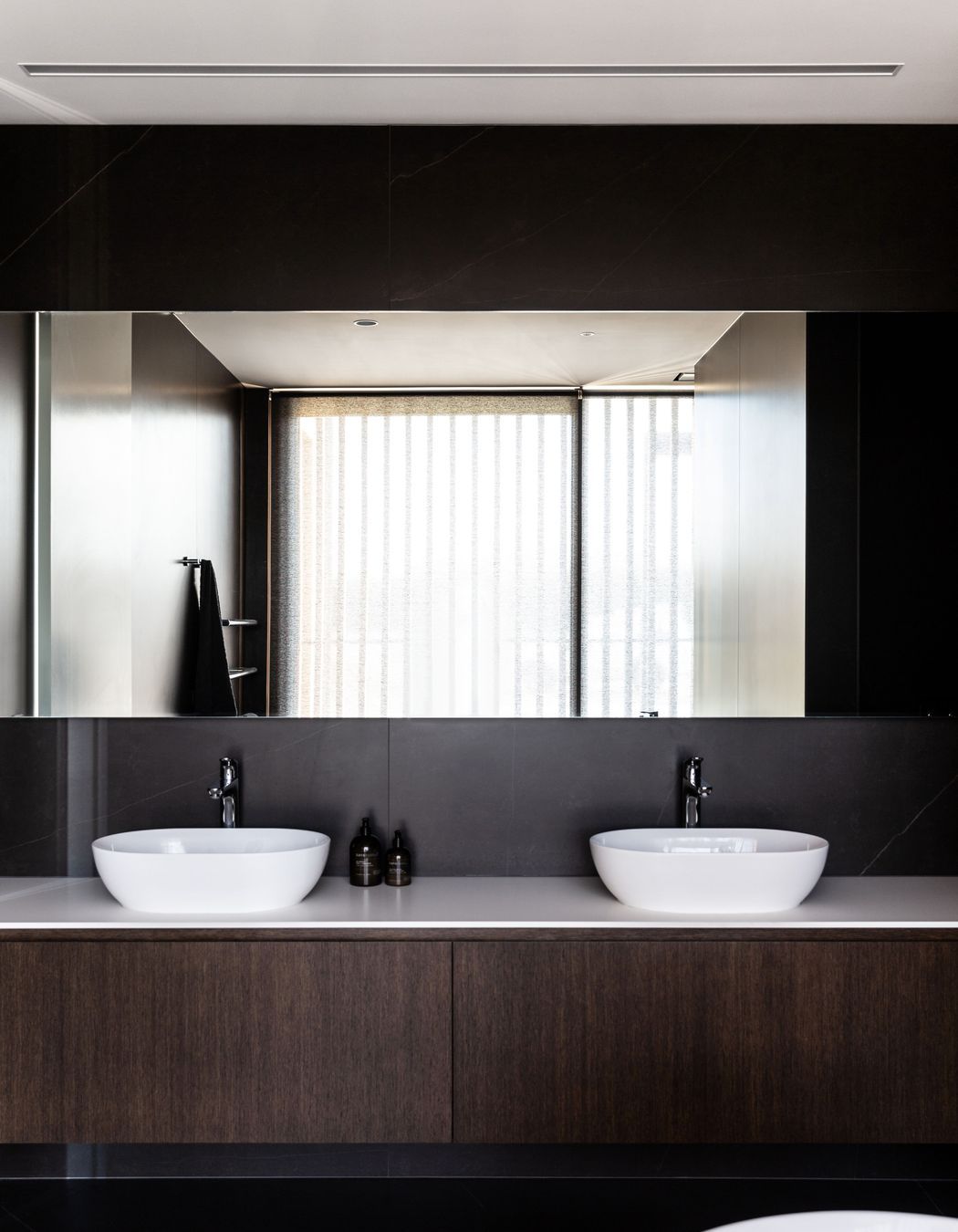 The main bathroom; expressing the same elegance and chocolate brown cabinetry as seen in the kitchen | Photographer: Anna McLeod