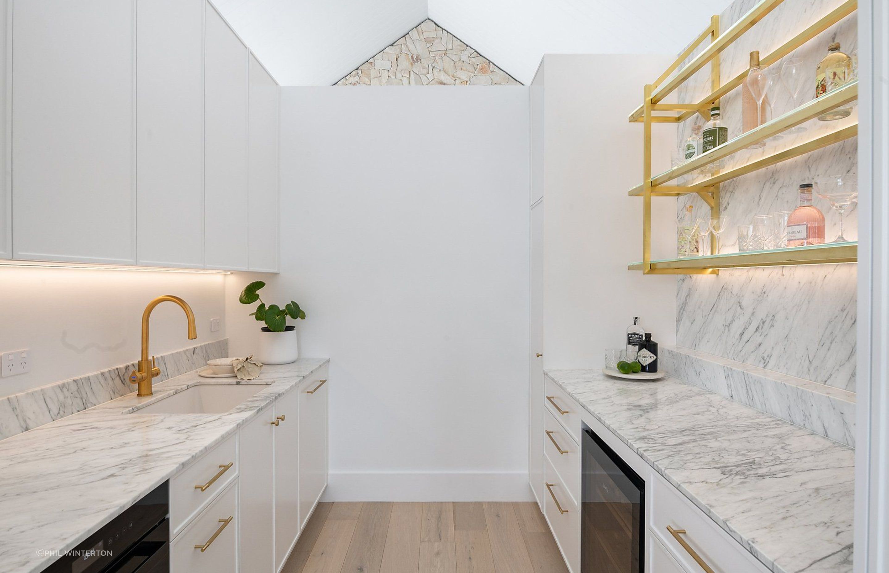 Brass finishes contrasts with marble in the butler's pantry.