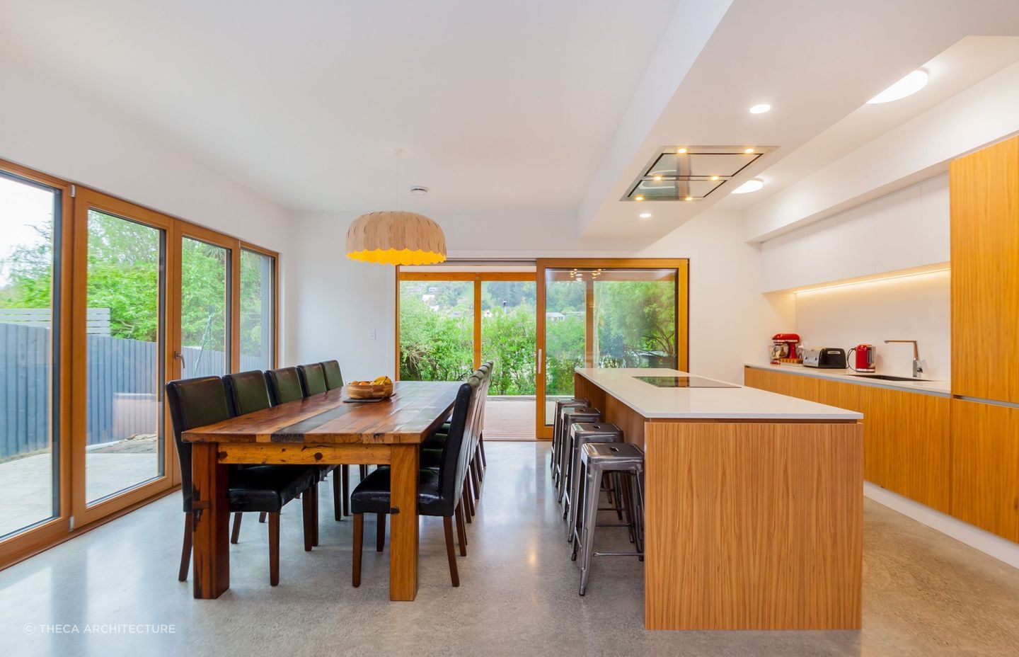 A spacious, open plan kitchen and dining area with triple-glazed timber-framed windows.