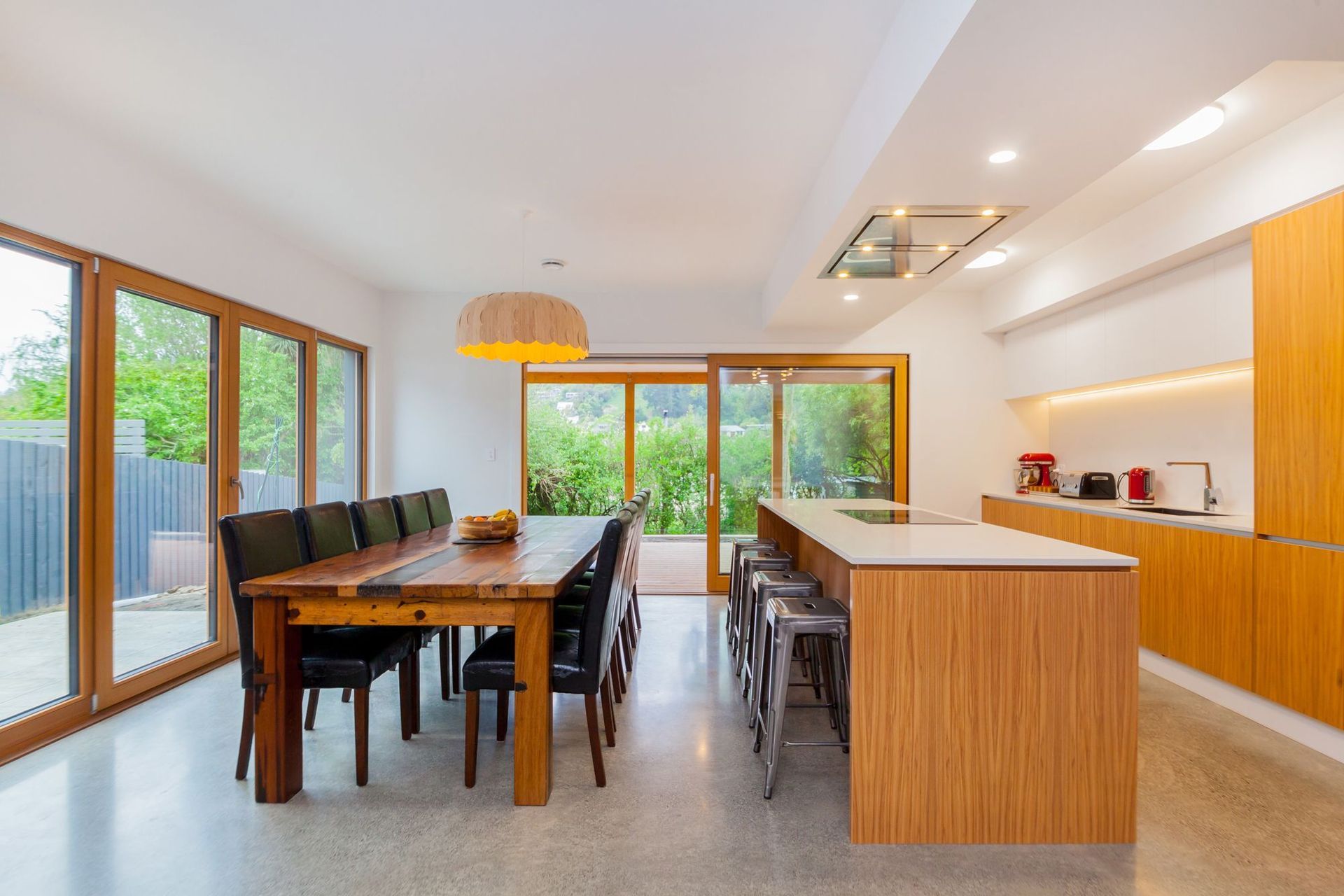 A spacious, open plan kitchen and dining area with triple-glazed timber-framed windows.