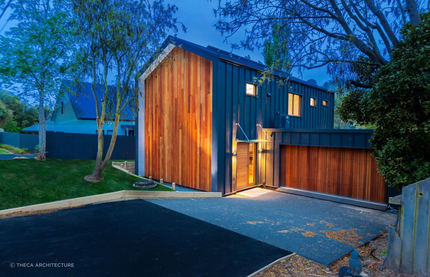 The entryway of the Pitkin-Douglas Passive House at night where solar panel-cladding can be seen on the north-facing roof.